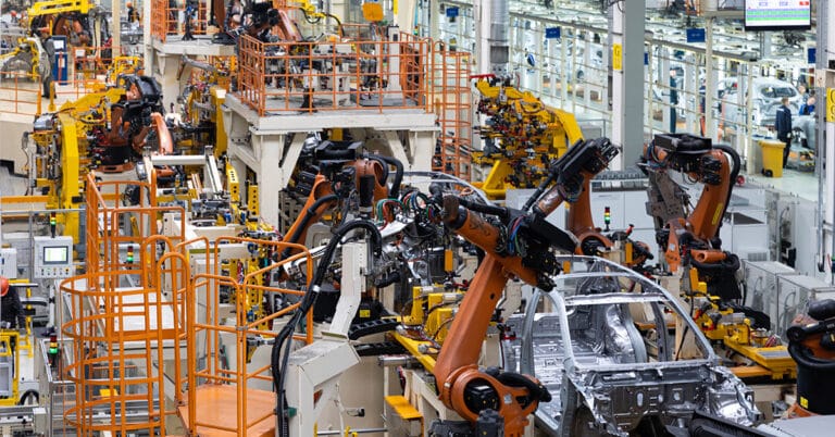 Car bodies on an assembly line in a modern automotive manufacturing facility.